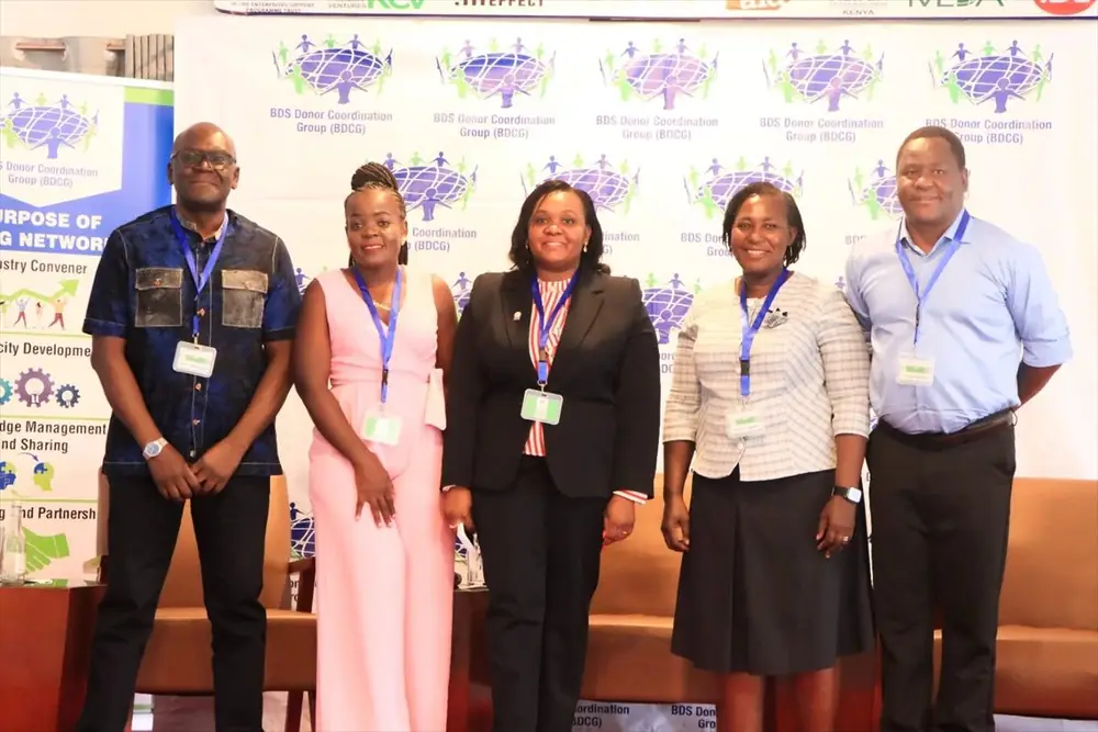 BDCG Conference delegates and panellists standing together in front of the BDCG backdrop